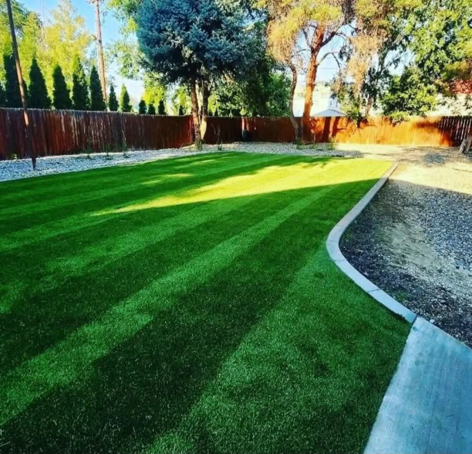 Striped lawn with curb edging and gravel